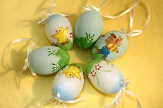 five painted eggs with animals on them are arranged in a circle, and tied together