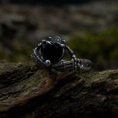 a black stone ring sitting on top of a tree branch