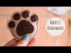 a hand holding a small crocheted animal paw shaped object with the words mary j handmade on it