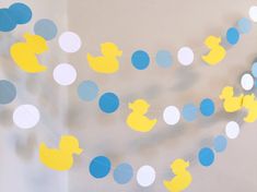 a party decoration with rubber ducks and polka dot garlands on a wall in a child's room