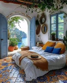 a bedroom with an arched window, bed and potted plants on the floor in front of it