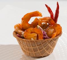 a basket filled with shrimp sitting on top of a white table