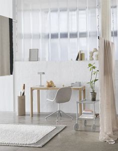 a room with a desk, chair and rug on the floor