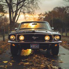 an old mustang sits parked on the side of the road in front of some trees