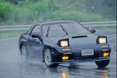 a car driving on a wet road in the rain