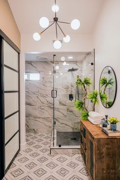 a walk in shower sitting next to a wooden dresser and mirror on top of a wall