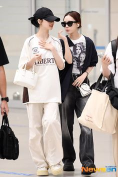 two young women standing next to each other in an airport