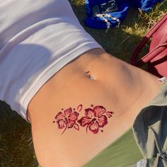 a woman's stomach with tattoos on it and flowers painted on the side of her belly