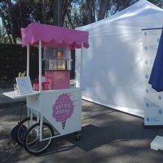 an ice cream cart sitting in front of a white tent