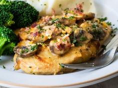 a white plate topped with chicken, broccoli and mashed potatoes covered in cheese