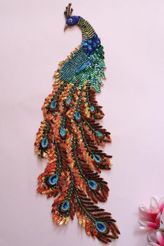 the colorful peacock is hanging on the wall