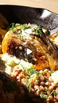 food is being cooked in a skillet on the stove with some garnishes