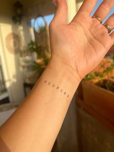 a woman's arm with the word respira written on her left wrist