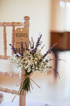 a bouquet of flowers sitting on top of a wooden chair next to a sign that says reserved