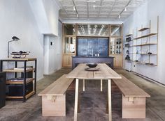 a large wooden table sitting in the middle of a room filled with shelves and furniture