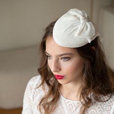 Bridal pillbox hat draped with ivory silk velvet having just a decent shine, adorned with a bow.  This millinery hat is complete handmade - hand blocked, shaped, covered with silk velvet fabric, lined on the inside and trimmed. The edge of hat is wired for long lasting durability and hand finished with a petersham ribbon and lining.  The hat is carefully designed to offer both style and comfort on your special day. The pillbox attaches to hair with hat elastics. It rests securely on your head, a Elegant Wedding Hat With Bow, Chic Wedding Hat With Bow, White Evening Hat Headpiece, Hair With Hat, Ivory Pillbox Hat, Adjustable Hat-shaped Wedding Fascinator, Velvet Hat, Silk Velvet Fabric, Pillbox Hat