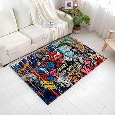 a living room with a white couch and rug covered in colorful graffiti art on the floor