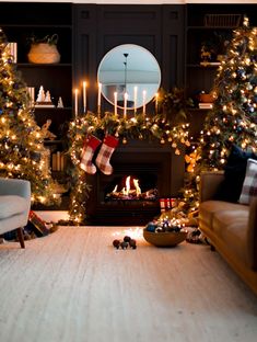 a living room decorated for christmas with stockings and candles on the fireplace mantels