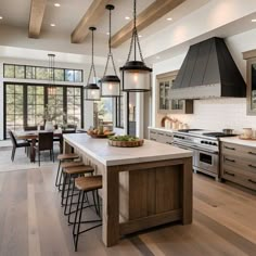 a large kitchen with an island, stove and dining room table in the center area