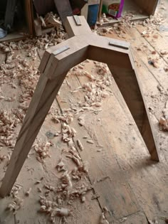 a wooden chair sitting on top of a floor covered in lots of wood shavings