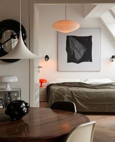 a bedroom with white walls and wooden flooring next to a bed in a loft