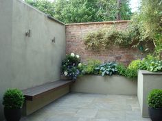 an outdoor patio with potted plants on the side and a bench next to it