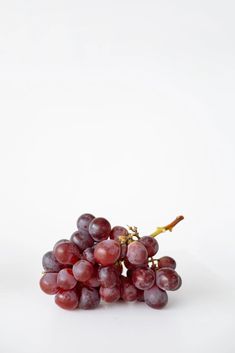 a bunch of grapes sitting on top of a white table