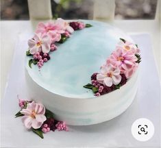 a cake decorated with pink flowers and greenery