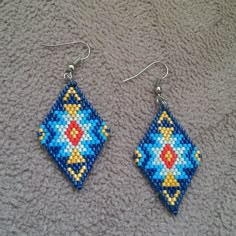 a pair of beaded earrings sitting on top of a carpet