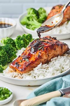 someone is using a fork to eat some chicken and rice with broccoli on the side