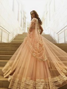 a woman standing on some stairs in a dress