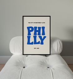 a poster with the words philly on it sitting on top of a white couch