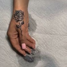 a woman's hand with a rose tattoo on it