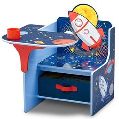 a wooden toy table with a rocket ship on it's top and drawers underneath