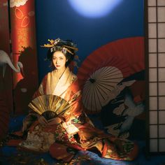 a woman sitting on the ground with an umbrella