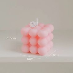 a bunch of pink balls sitting on top of a white table next to each other