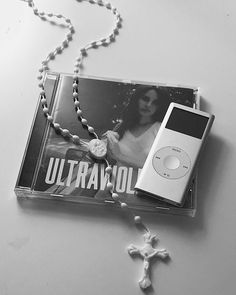 an mp3 player and rosary laying on top of a cd case with the word ultravol printed on it