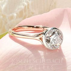 a diamond ring on top of a pink flower