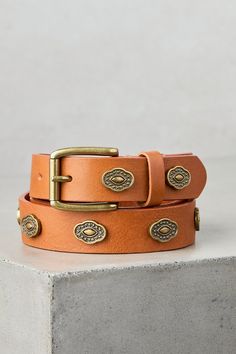 Exuding rustic charm and timeless adventure, the Balaton western leather belt is a testament to unparalleled artisanship. While artisan crafted of durable leather cowhide in earthy tones, Balatan maintains an understated spark of interest, from its antiqued metal medallions on its strap to its sturdy, eye-catching metal buckle. Sheepskin Slippers, Belt Style, Western Leather, Antique Metal, Belt Size, Leather Belts, Artisan Craft, Leather Care, Earthy Tones