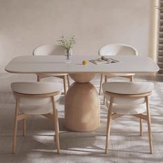 a white table with four chairs and a vase on the top, in an empty room