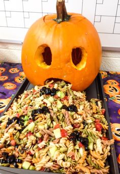 a pumpkin sitting on top of a tray filled with food