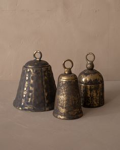 three metal bells sitting next to each other on a table