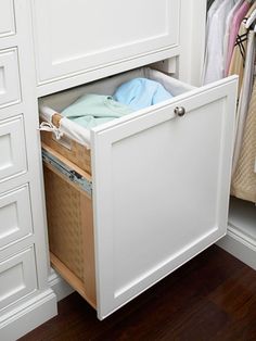 an open drawer in a closet filled with clothes