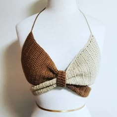 a white mannequin wearing a brown and beige top with a bow tie on it