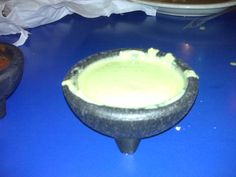 a bowl filled with green liquid sitting on top of a blue counter