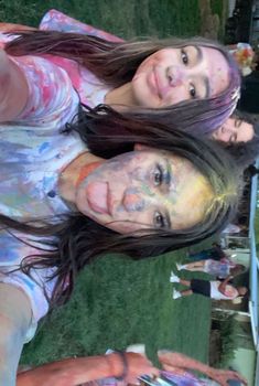 two young women are posing for a photo with their hands painted in different colors and shapes