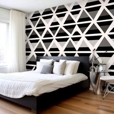 a bedroom with black and white geometric wallpaper