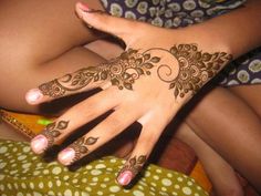 a woman's hand with henna tattoos on it