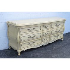 an old dresser is painted white with black trim