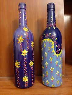 two purple vases with yellow flowers painted on them